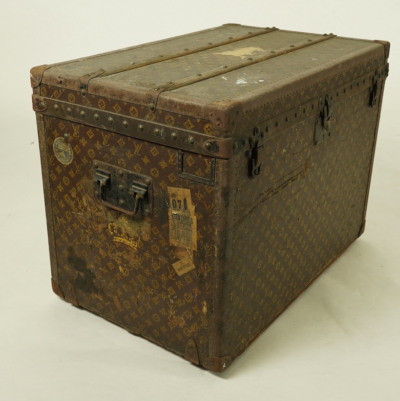 A vintage Louis Vuitton trunk, with black painted iron banding, wooden slats and canvas LV fabric, label for Paris, New Bond Street, Nice and Lille, numbered 776719, the interior with original tray, 76cm wide, 49cm deep,